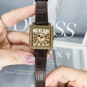 Primer plano de un reloj cuadrado con diamantes, números grandes y correa de piel marrón