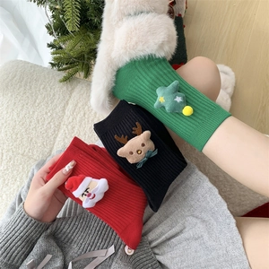 Detail of Christmas crew socks with 3D plush Santa, reindeer, and tree appliques