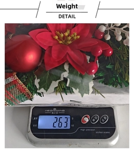 Detailed view of red poinsettia Christmas wreath showing weight at 263g on a digital scale