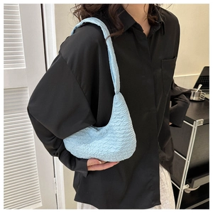 Detail showing light blue pleated shoulder bag with a soft bubble texture and cloud-like design