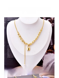 Detail of gold U-link chain necklace featuring a square lock pendant and a white pearl drop