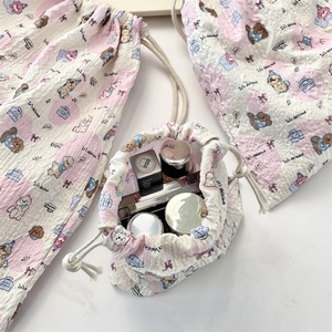 Detail of seersucker drawstring pouch showing portable storage for cosmetics and toiletries