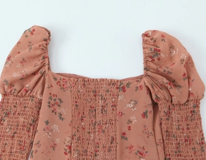 Détail du col carré et des smocks élastiques sur haut à fleurs et manches bouffantes