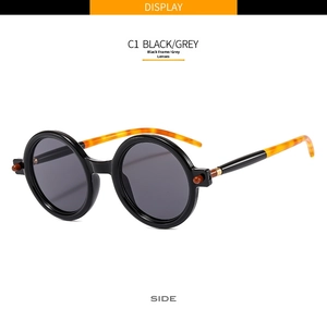 Side view of retro round sunglasses with black frames and tortoise pattern ear tips