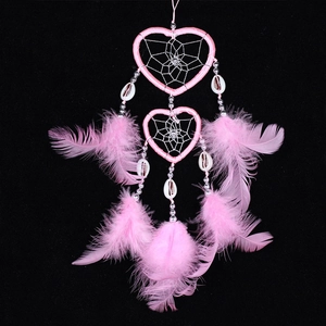 Pink heart-shaped dreamcatcher with feathers, silver beads, and shells on black background