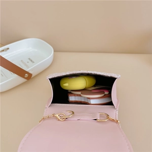 Pink pearl crossbody bag for kids with tweed flap and gold chain strap shown from above