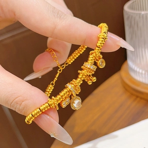 Detail of 24k gold plated bracelet with sparkling zircon flower charms and lobster clasp