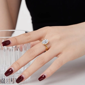 Close-up of golden S925 silver ring with large oval ice-cut zircon on female hand