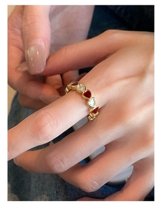Close-up of gold plated ring with alternating red enamel and zircon hearts