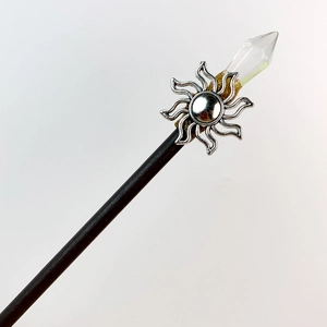 Detail of wooden hair pin featuring silver sun totem and transparent crystal point