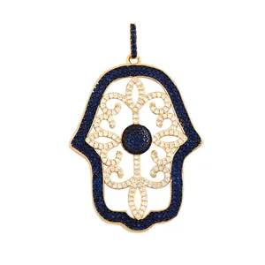 Detailed view of a Hamsa hand pendant featuring gold plating and blue cubic zirconia stones