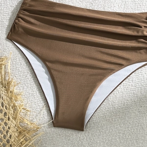 Detail of high waisted brown bikini bottoms featuring stylish ruched fabric and texture