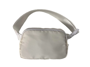Close-up of lightweight off-white nylon waist bag featuring zip closure and adjustable strap
