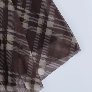 Gros plan sur un tissu de tulle à carreaux marron montrant la texture en maille fine