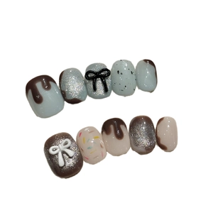Faux ongles faits main motif chocolat 3D avec nœuds et finition pailletée chic