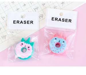 Detail of pink and green unicorn donut erasers in transparent packaging on pink background