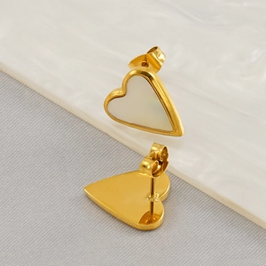 Detail view of heart-shaped gold studs with white inlay and butterfly clasp backing