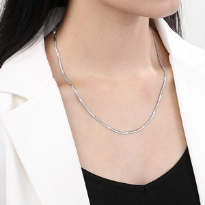 Primo piano di una collana a serpente in acciaio inossidabile argento su una donna