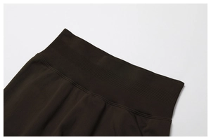 Detail view of high-waist ribbed elastic waistband on dark brown fitness leggings