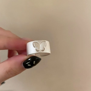Detailed view of silver matte hollow butterfly open ring on hand with wave geometric edges