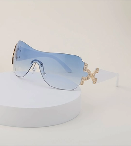 Close-up of blue gradient oversized sunglasses with gold rhinestone temple details