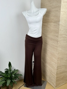 Detail of brown wide-leg knit trousers with double-layered waist and white camisole