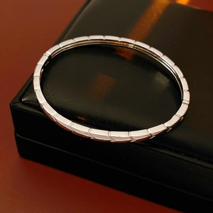 Detailed macro shot of geometric square link metal bracelet on black leather gift box
