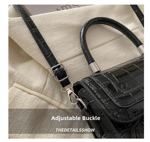 Close-up of black crocodile pattern leather bag featuring silver metal buckle and hooks