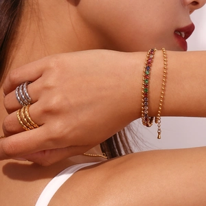 Detail of 18K gold plated twisted rings and double-layer bracelet with colorful zircons