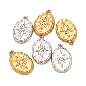 Macro detail of oval titanium steel charms with star engraving and inlaid crystal