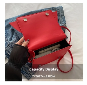 Interior view of red bat bag showing storage capacity for phone and wallet with magnetic buckle