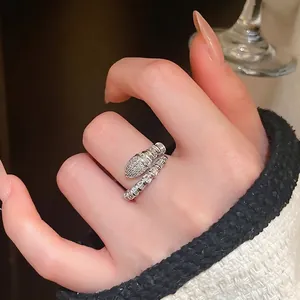 Elegant silver snake-shaped open ring with cubic zirconia crystals worn on the finger