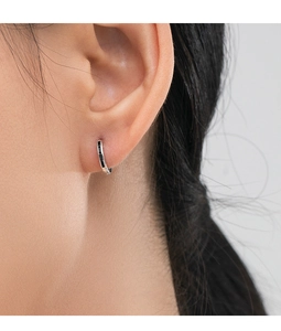 Close-up of S925 sterling silver hoop earring with black zircon on model's ear