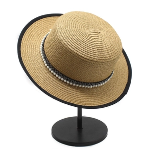 French vintage boater straw hat with black trim and pearl beads on display stand