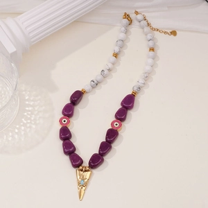 Detail of beaded necklace with amethyst, marble stone, and golden sun charm pendant