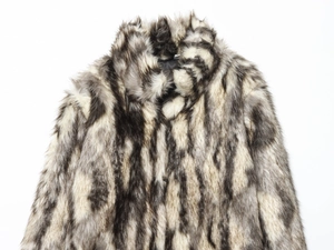 Close-up detail of textured faux fur fabric in grey and white on a long sleeve coat
