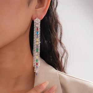 Close-up of luxury tassel earrings featuring rainbow gemstones and silver-tone fringe