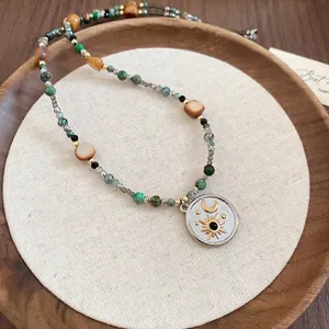 Collier rétro en acier inoxydable avec pendentif lune et étoile sur plateau en bois