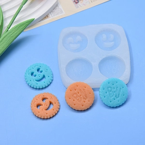 DIY silicone mold with cookie shapes and resin biscuit samples on blue background