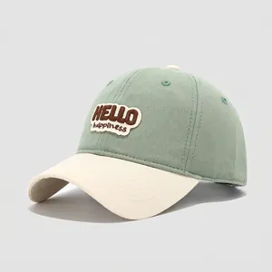 Detail of mint green and cream patchwork cotton baseball cap with HELLO embroidery