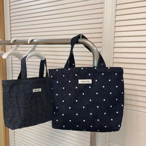 Detail of dark blue denim tote bags with polka dots and simple wish fabric label