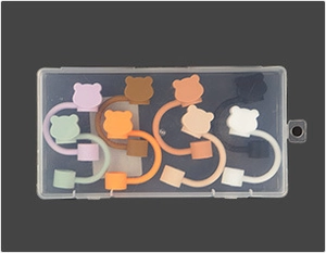 Macro detail of various colorful bear-shaped silicone cable organizers in a storage box