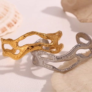 Detail of 18K gold and silver wavy hollow bangles with water droplet texture on surface