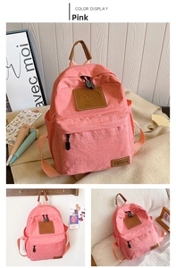 Detailed view of pink canvas backpack featuring smiley patch and leather handle for kids