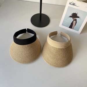 Top-down view of woven open-top straw hats with contrast bands and natural texture