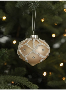 Detailed champagne pear-shaped Christmas ornament with white beads and rhinestones on a tree