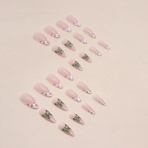 French almond press-on nails with floral patterns and green butterfly designs