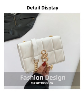Detail showing white quilted texture and gold metal SS logo on the crossbody bag