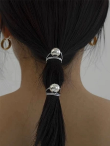 Detail of two sparkling silver sphere hair ties styling a ponytail with elegant polish