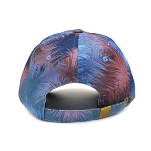 Detail of tie-dye baseball cap back showing copper metal buckle and palm leaf print